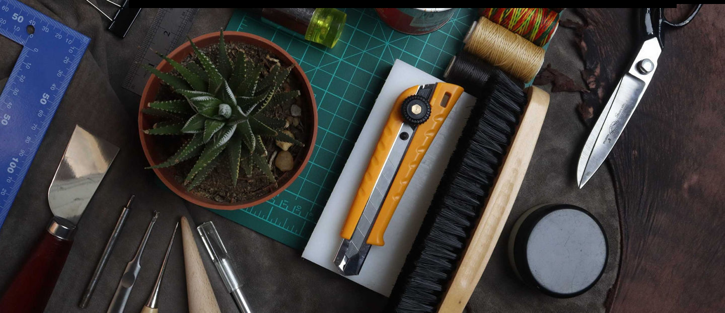 Craft tools, thread, and a cutting mat on a worktable
